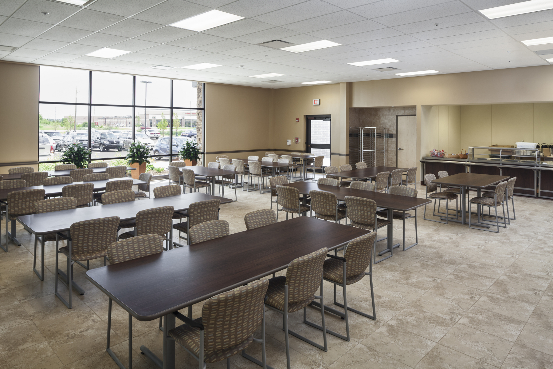 Cafeteria with tables, chairs, and serving area