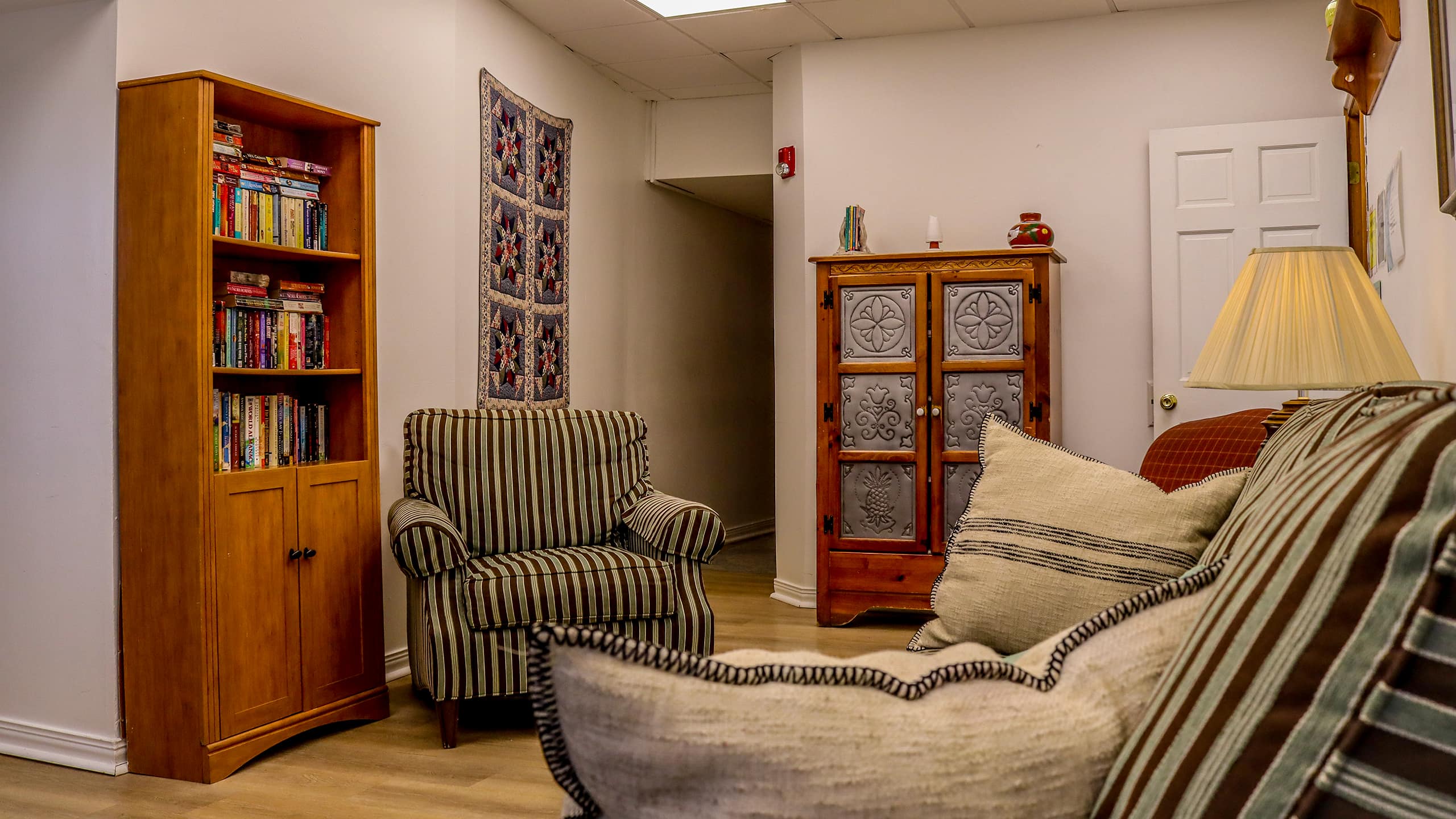 Lounge with striped furniture, bookshelves, and wall decor