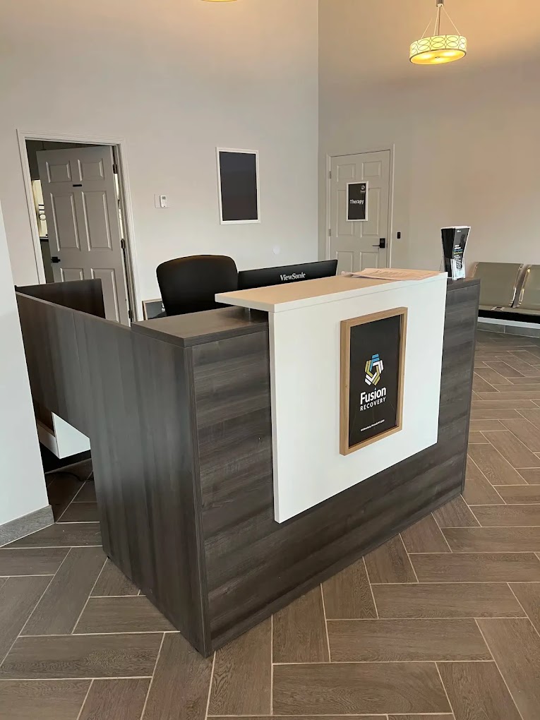 A reception desk at Fusion Recovery Centers with a dark wood finish.