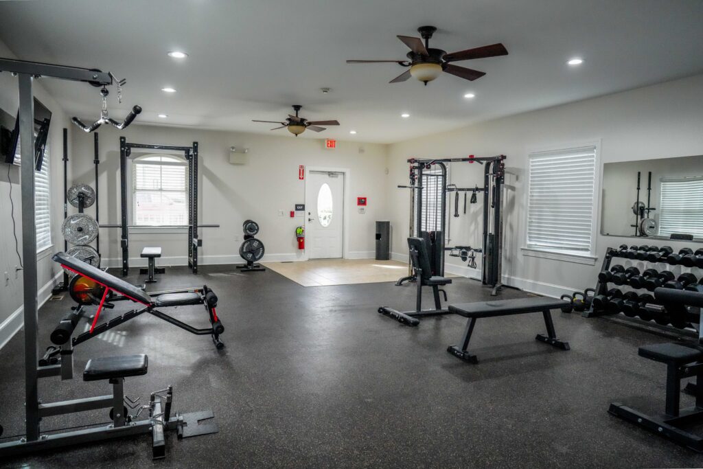 Gym with weight benches, racks, and mirrors