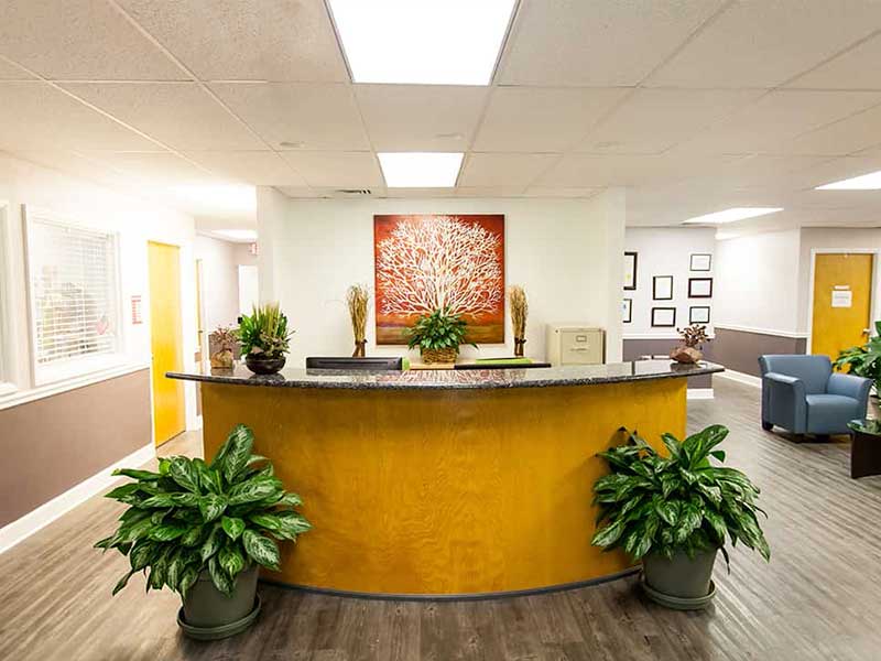 Reception desk with plants and artwork in lobby