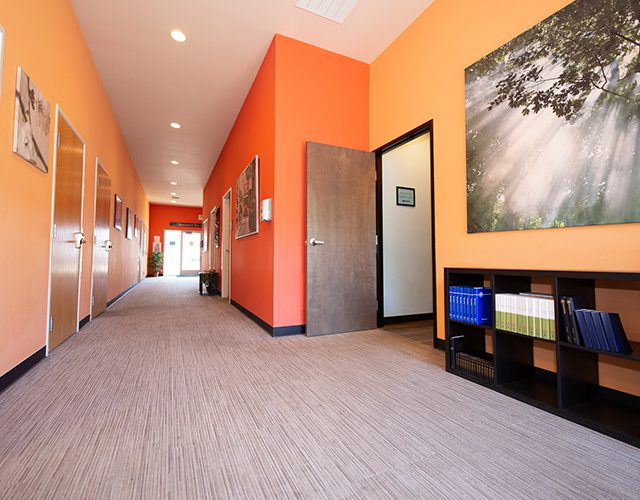 Bright orange hallway with doors and open office entrance