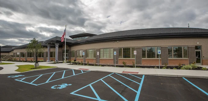 Modern one-story building with parking lot and flagpole