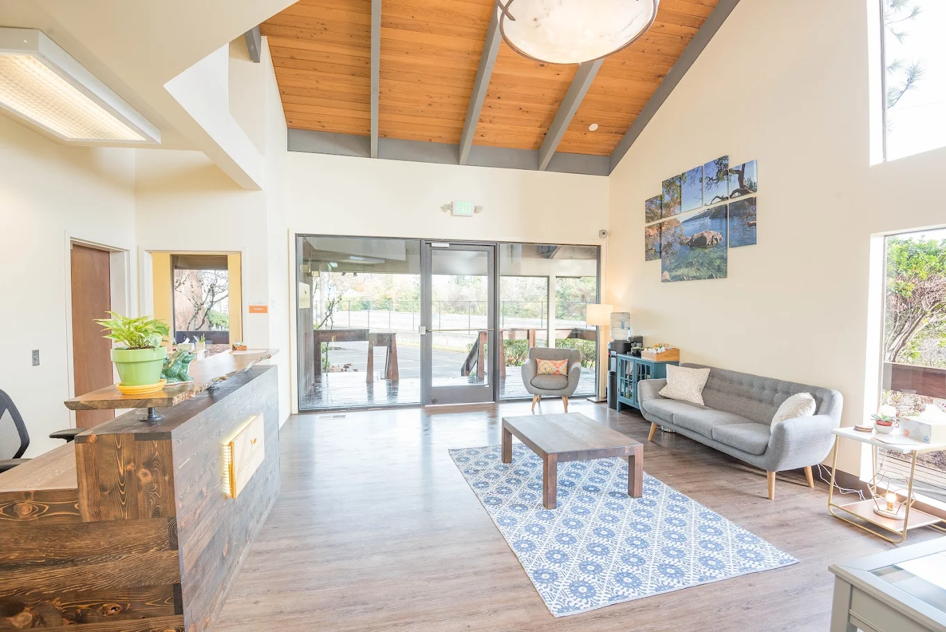 Welcoming lobby area with wooden reception desk, cozy seating, natural lighting, and modern decor