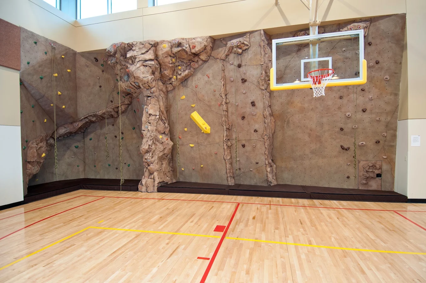 Indoor recreation area with rock-climbing wall and basketball hoop