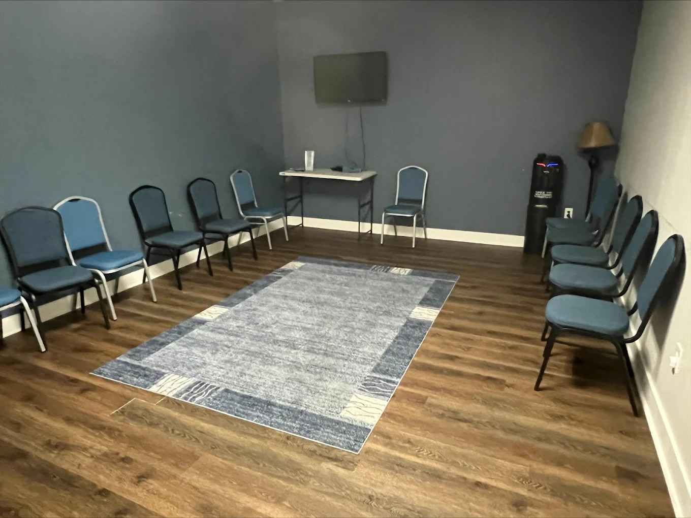 Circle of chairs in therapy room with blue walls and rug