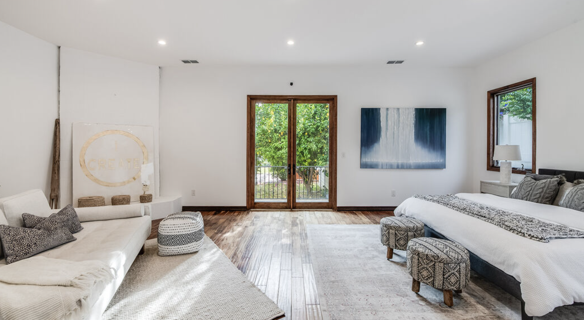 Spacious bedroom with white decor and outdoor view