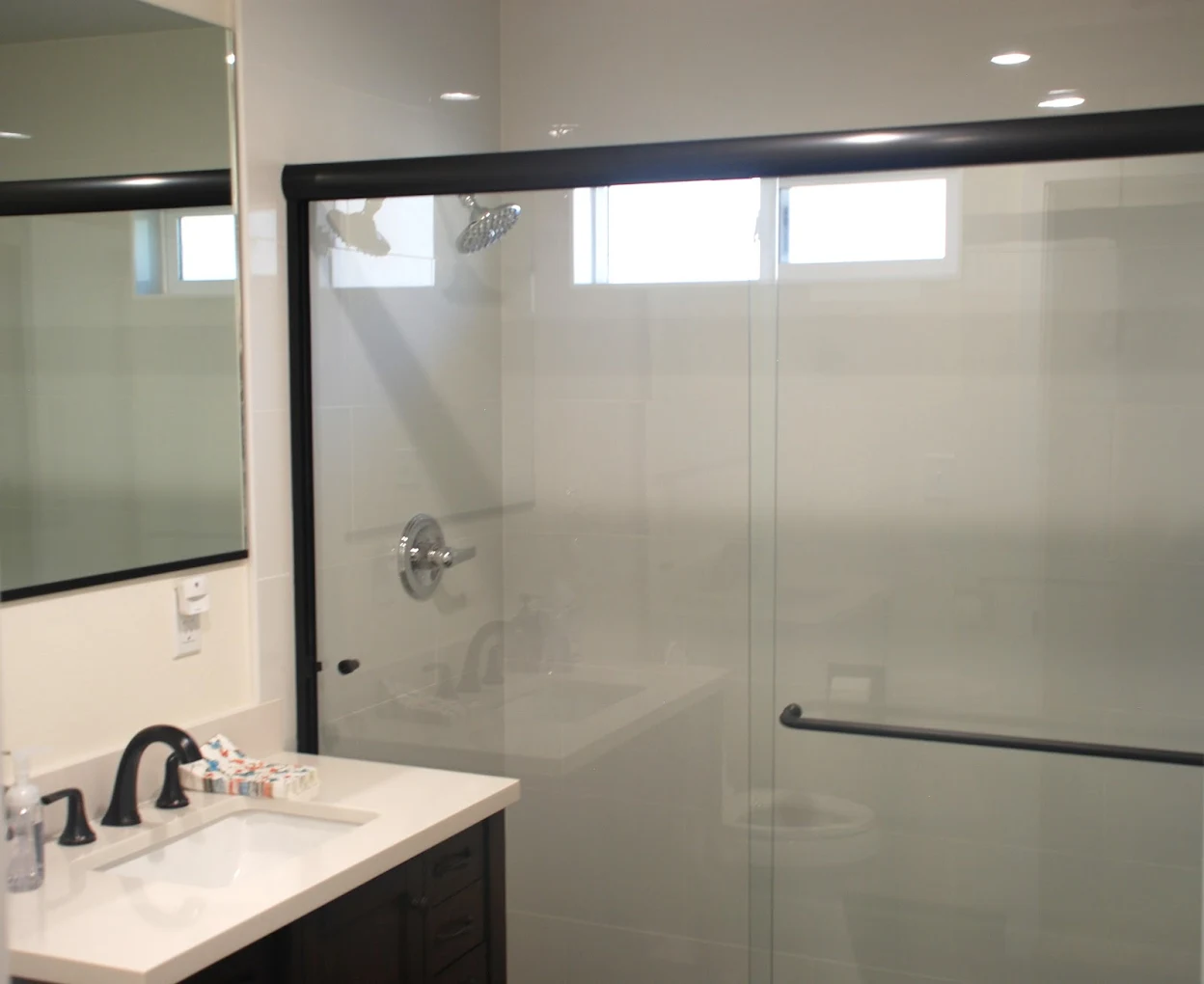 Glass shower with modern vanity and mirror