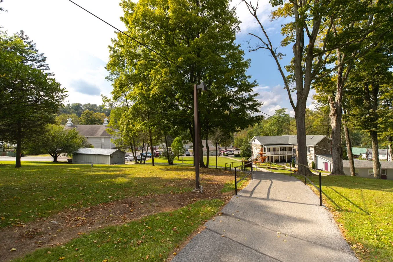 Tree-lined path leading to rehab facility campus buildings