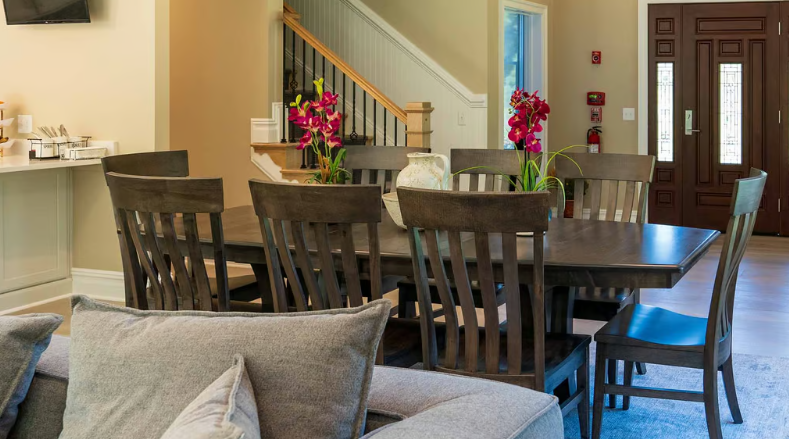Spacious dining room with large table and dark wood chairs