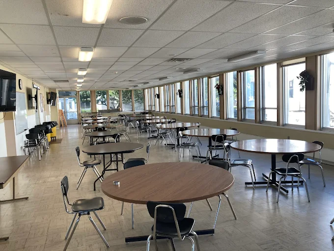 Large cafeteria with round tables and windows