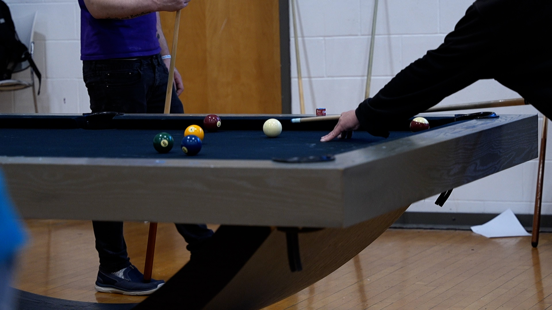 People playing pool on a modern table in recreation room