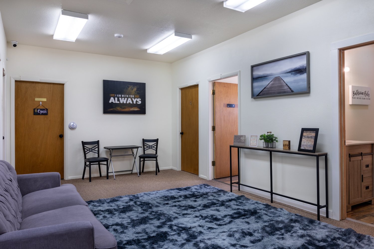Lounge area with a couch, rug, and framed wall decor