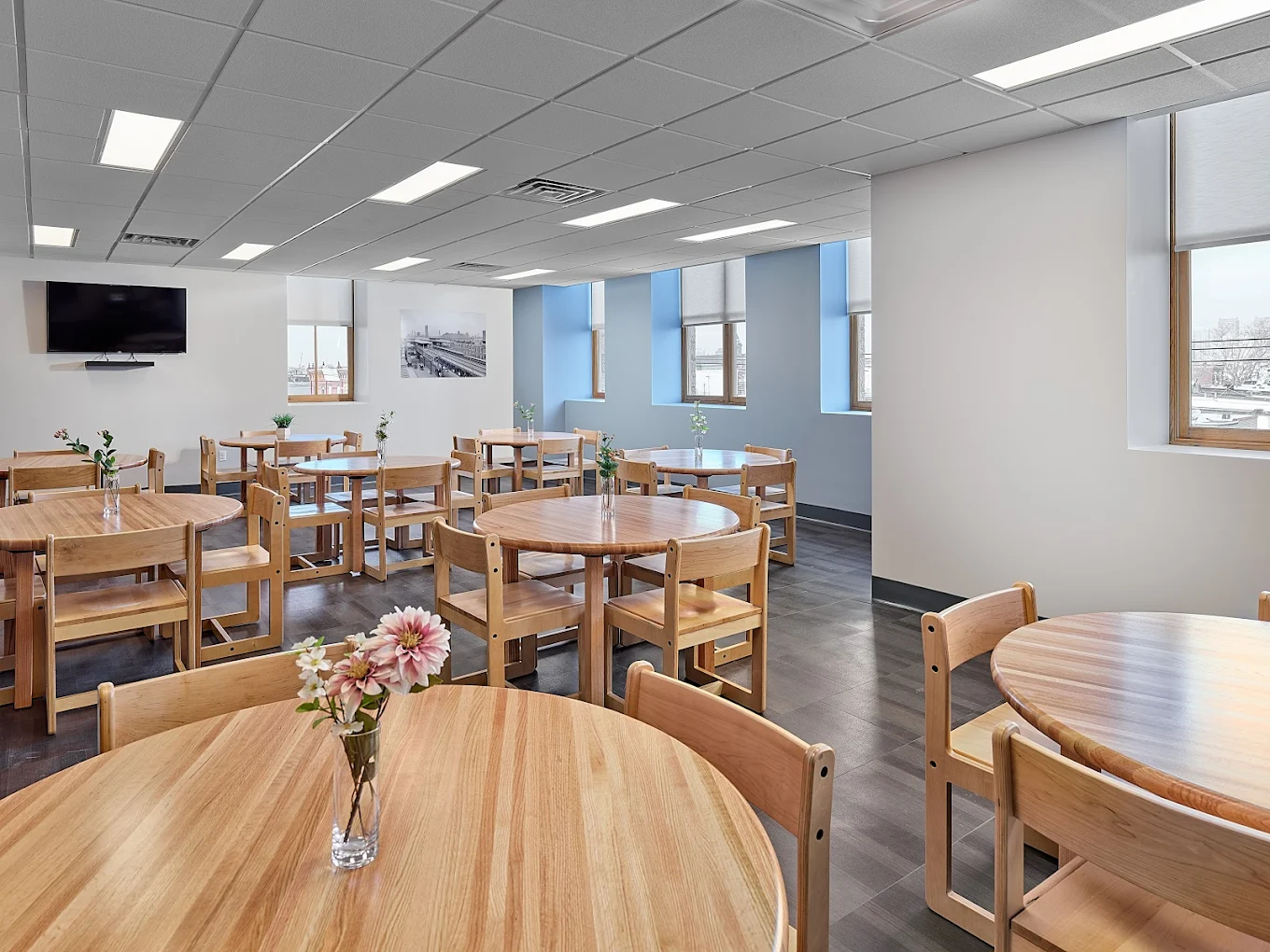 Spacious dining room with round wooden tables and chairs