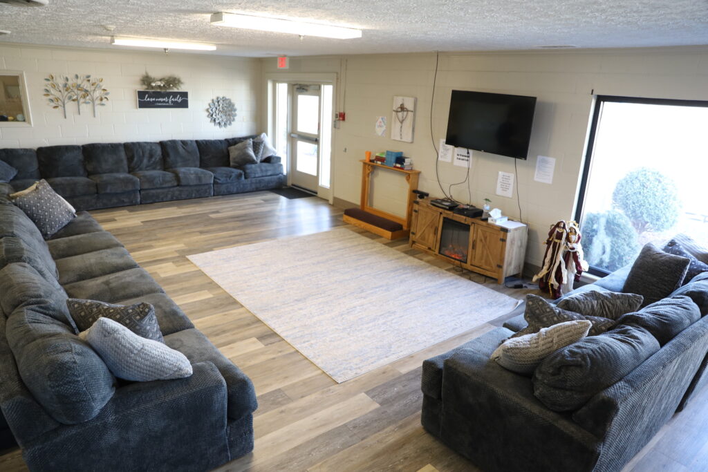 Spacious lounge with sectional couches and TV on the wall
