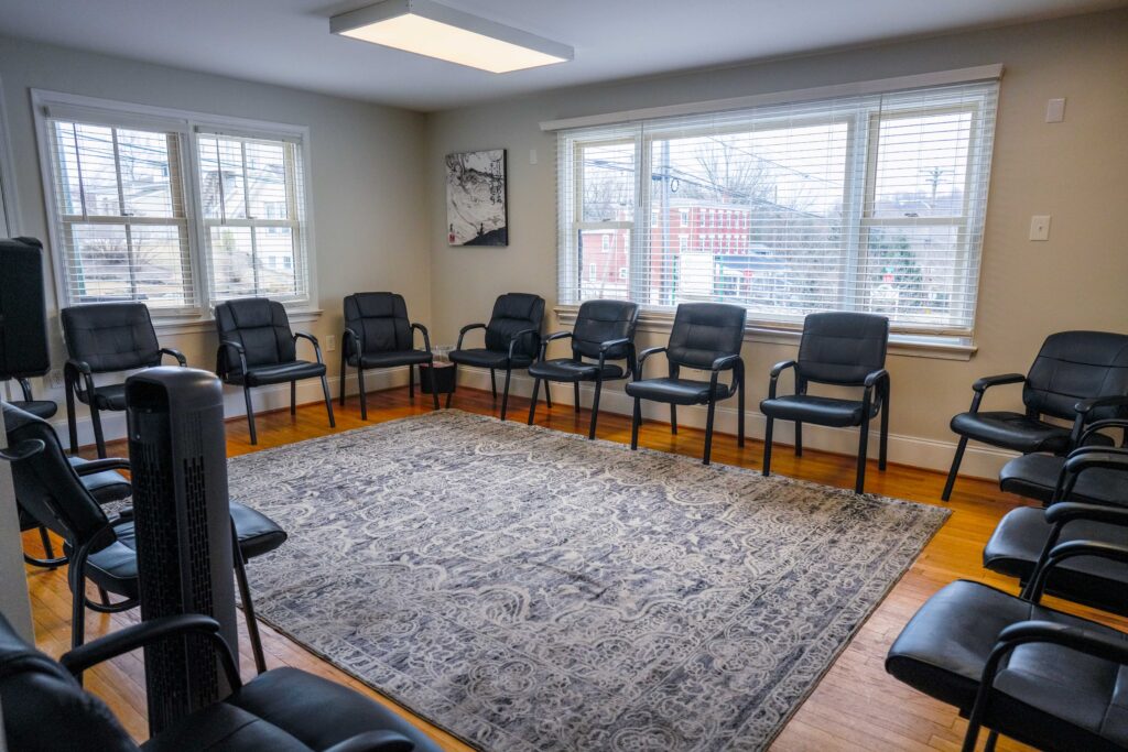 Circle of chairs with large windows and a rug