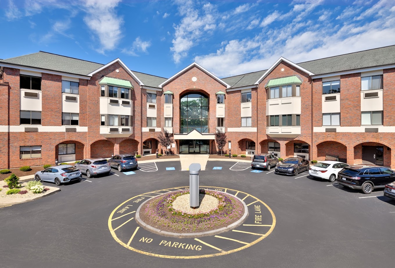 Exterior view of a brick rehab center with parking.