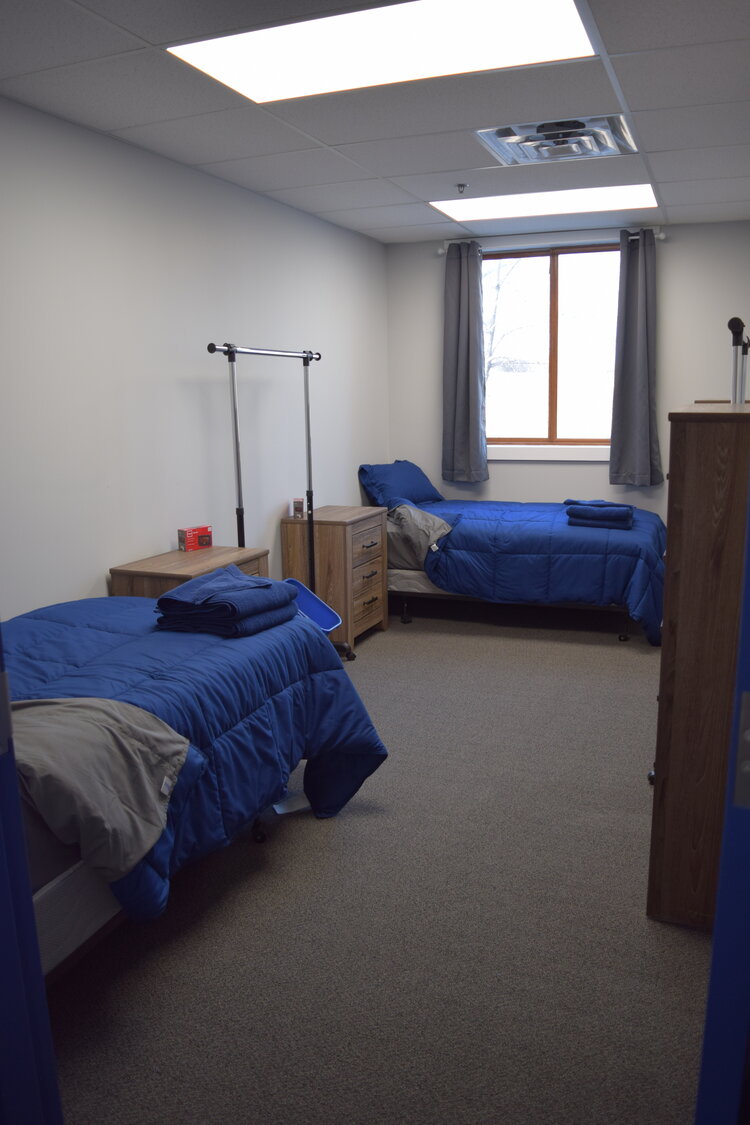 Two single beds with blue comforters in shared room