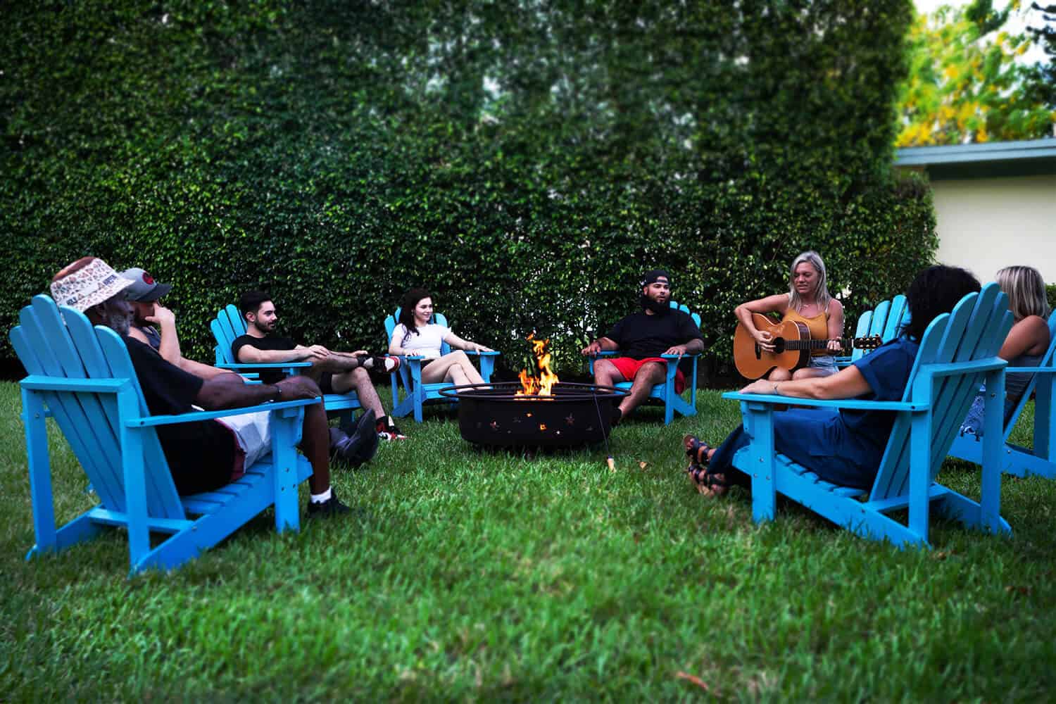 Group seated in chairs around outdoor fire pit