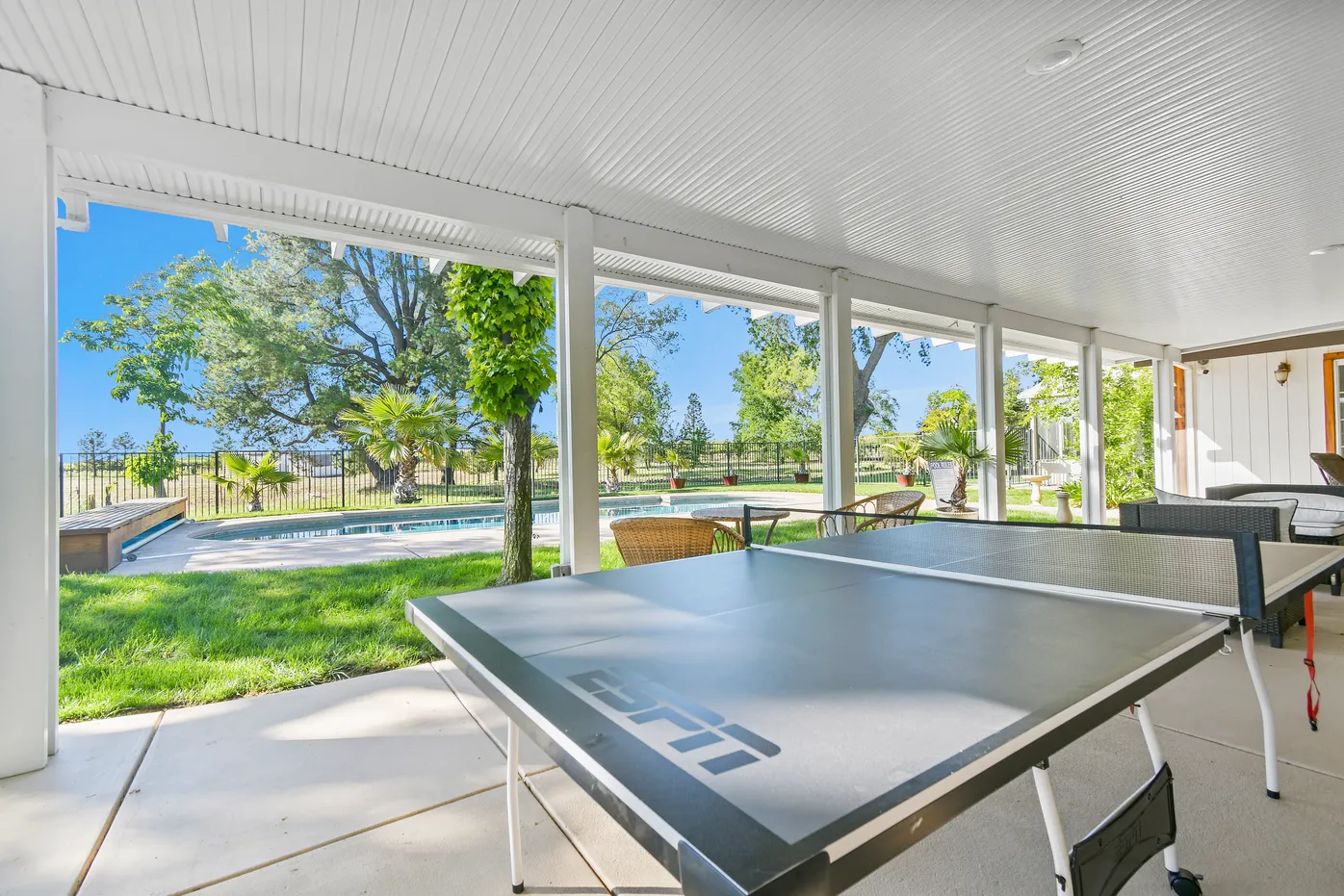 Covered patio with ping pong table near pool
