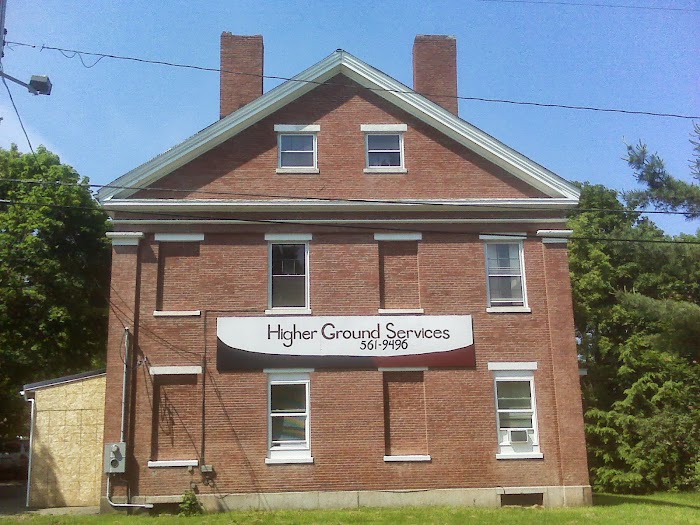A welcoming red-brick building with a sign for Higher Ground Services, providing a professional and supportive environment.