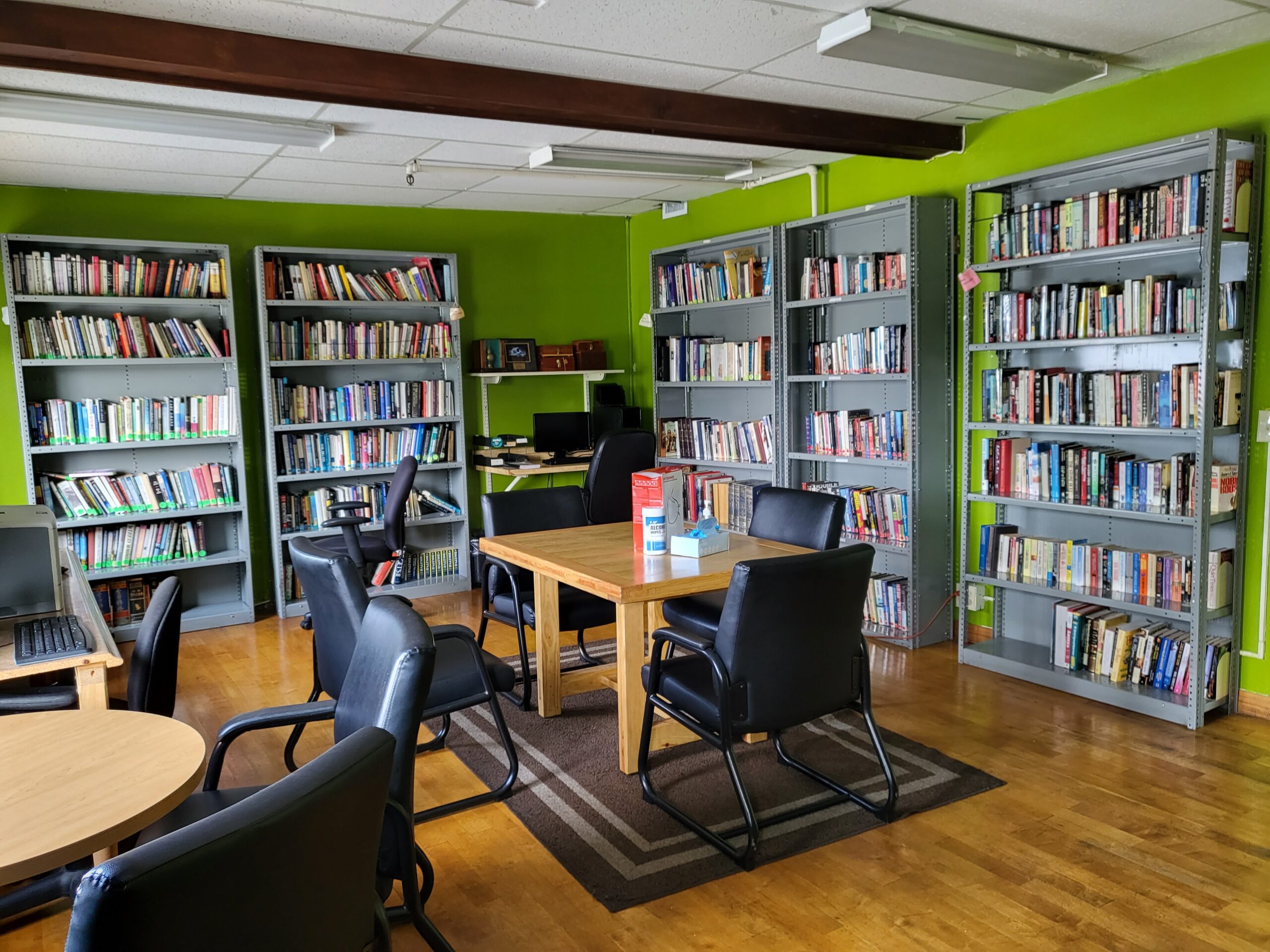 Library with bookshelves, tables, and chairs in a rehab facility in Los Angeles