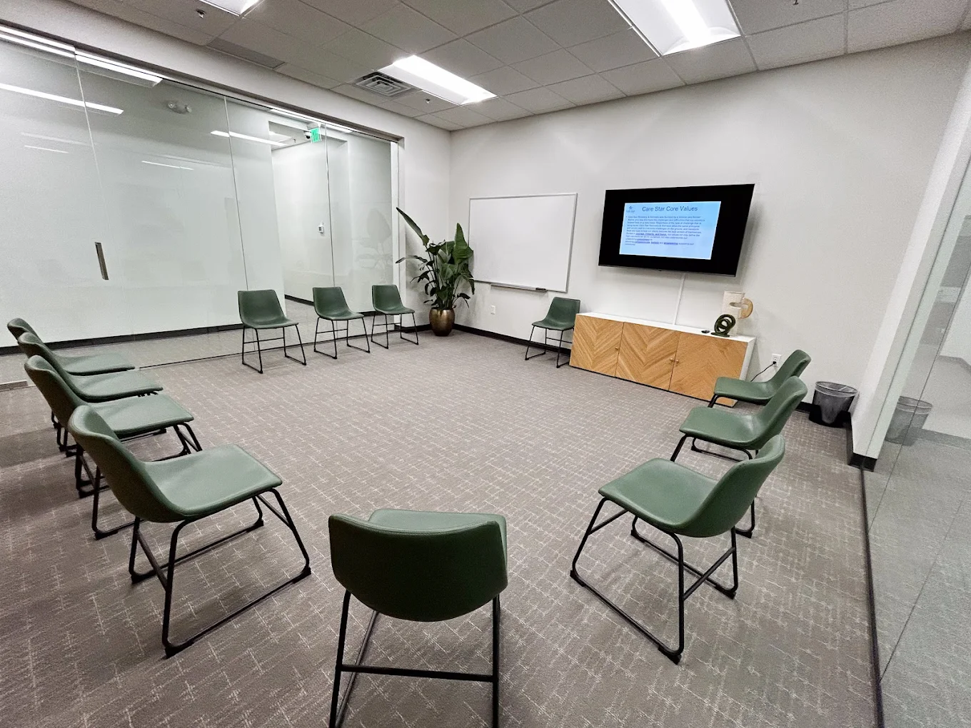 Meeting space with green chairs and TV
