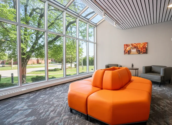 Bright lounge with large windows and orange seating