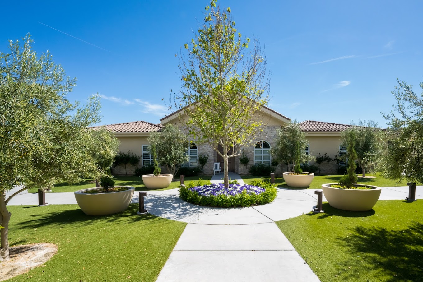 Rehab facility exterior with landscaped gardens and a central walkway.