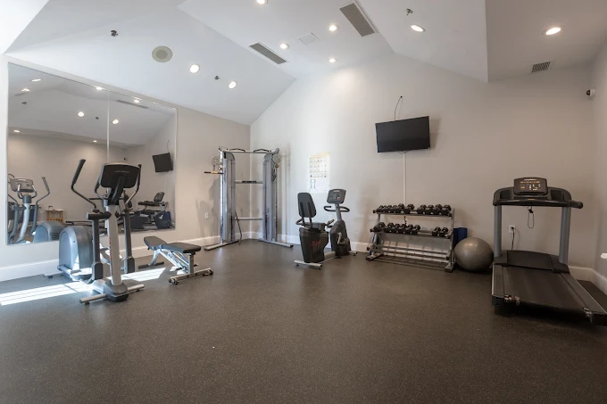 Fitness room with treadmill, weights, and exercise machines