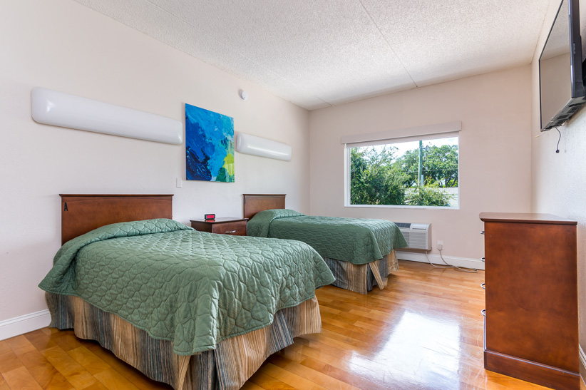 Shared bedroom with two single beds and a dresser.