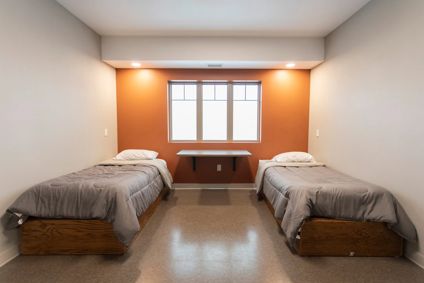 Shared residential bedroom with two twin beds and window