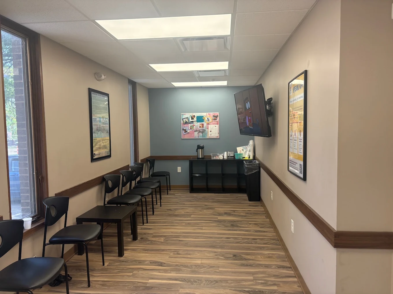 BrightView Akron interior waiting area with patient seating, wall-mounted television, informational posters, and refreshment station