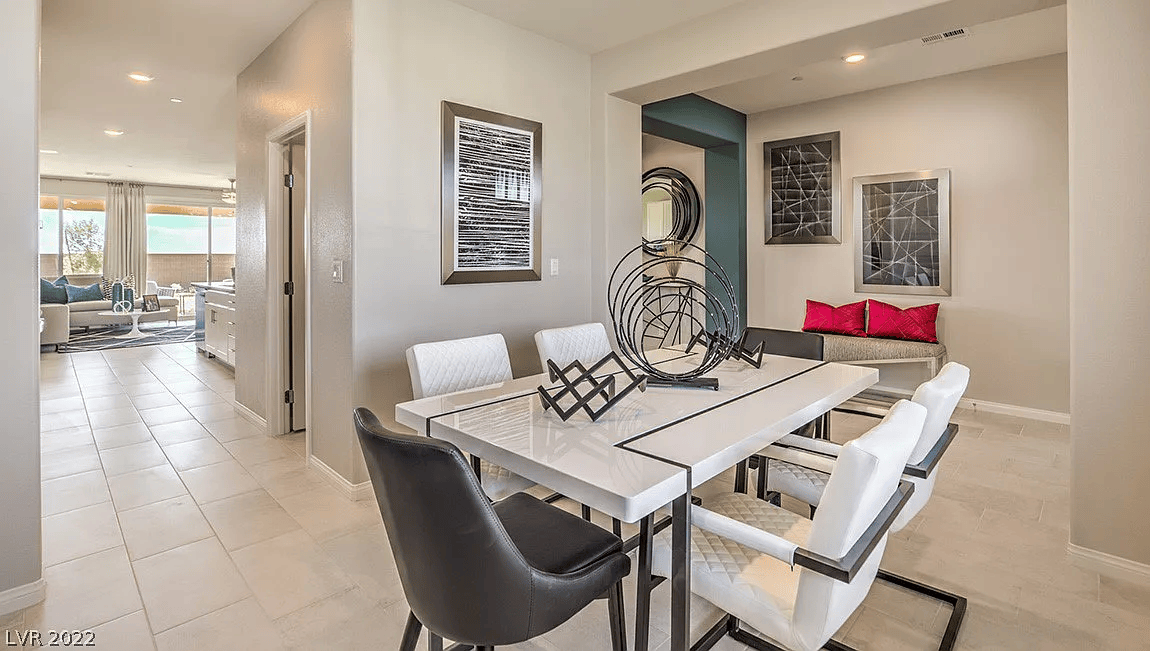 Contemporary dining room with large table, modern chairs, wall art, and tiled flooring