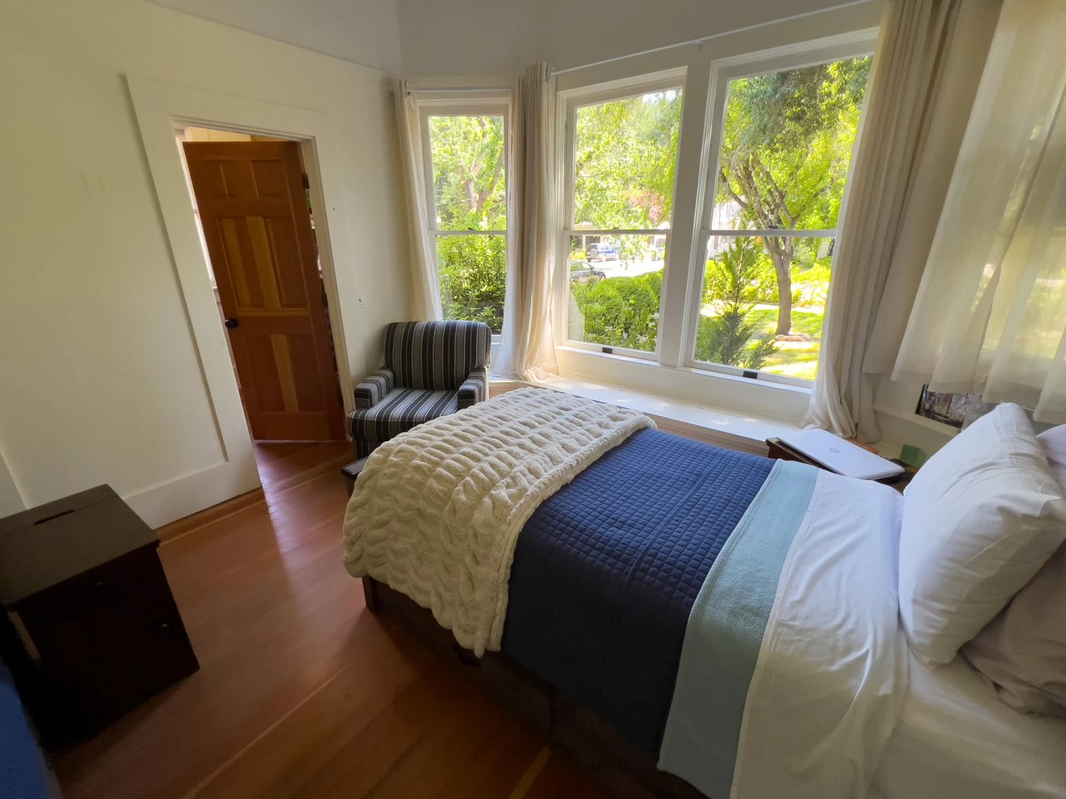 Bright private bedroom with large windows and garden views