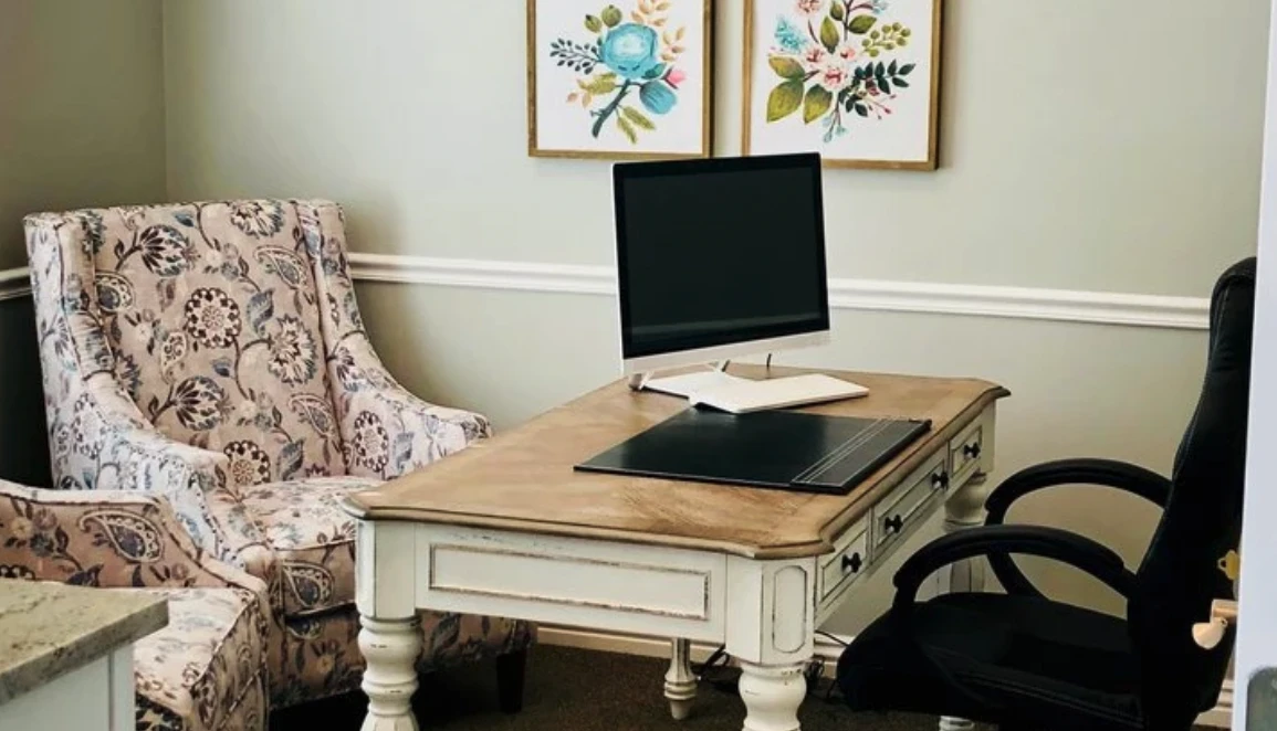 Elegant consult room with floral chair, desk, and computer setup