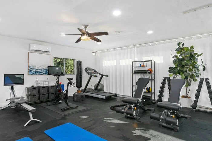 Modern fitness room with treadmill, bike, and free weights