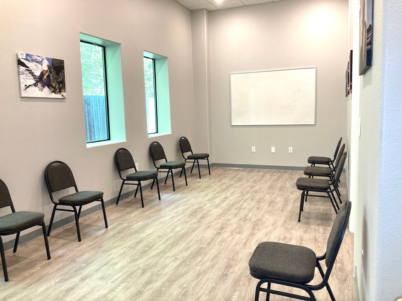 A therapy room with chairs arranged in a circle and a whiteboard on the wall.