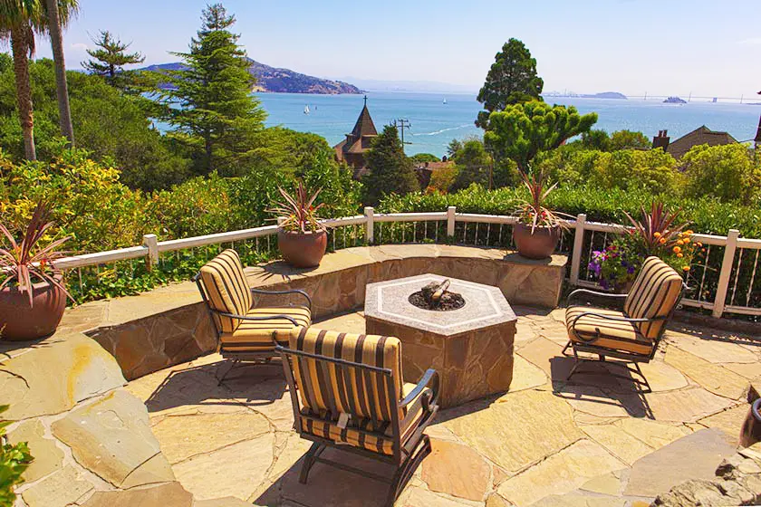 Patio with chairs and fire pit overlooking bay