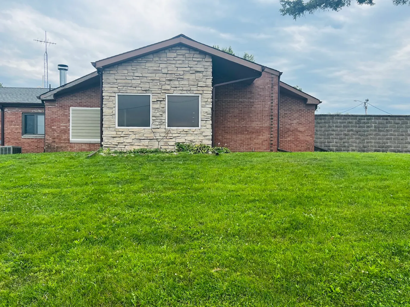 Brick facility building with a large green lawn
