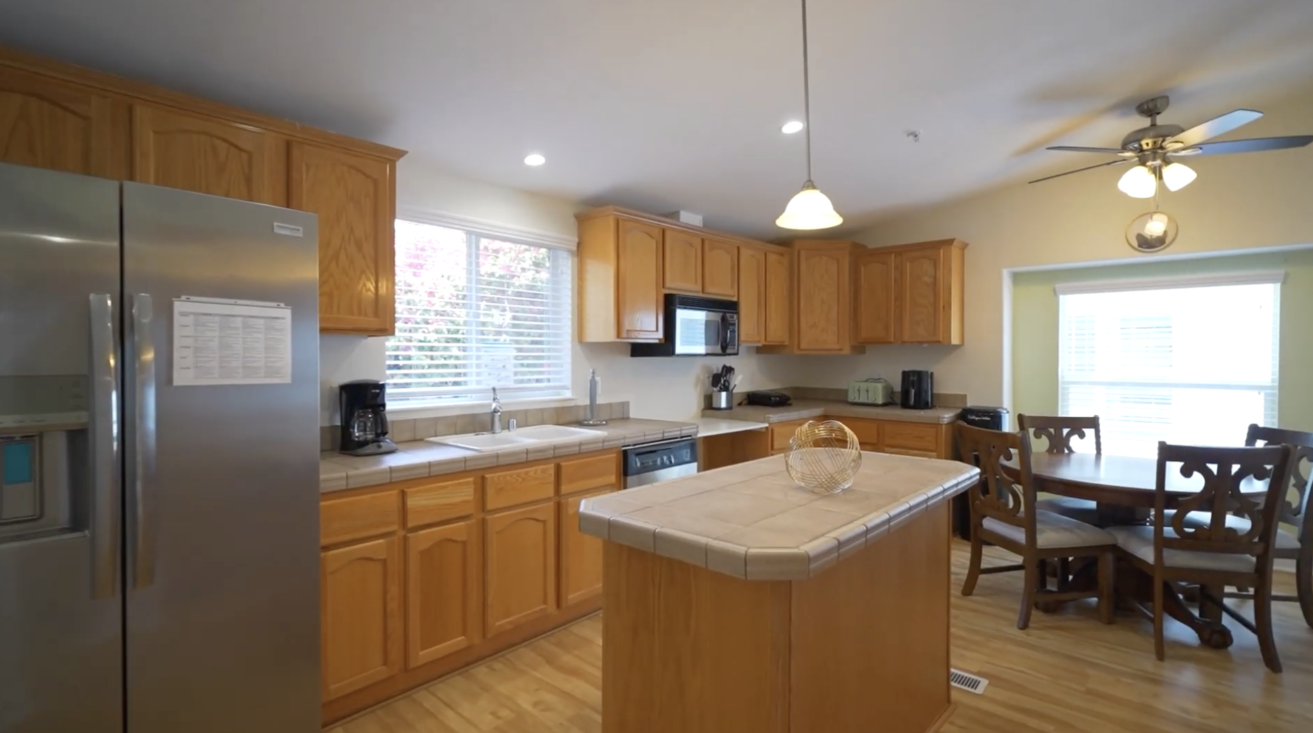 Full kitchen with wood cabinets, island, and dining table