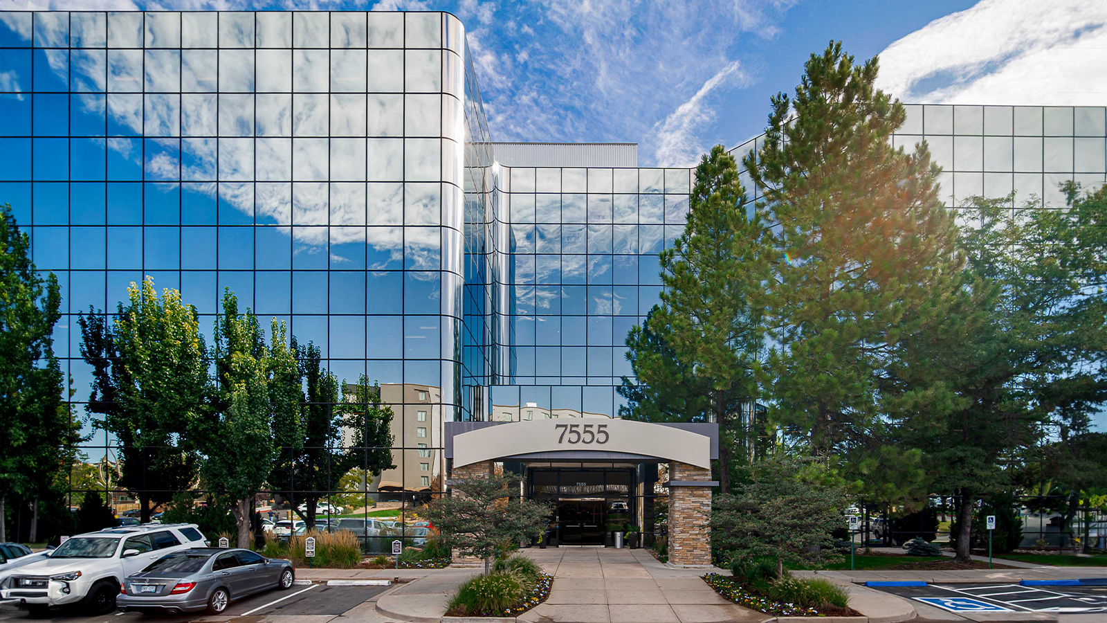 Facility exterior with glass facade and entry walkway.