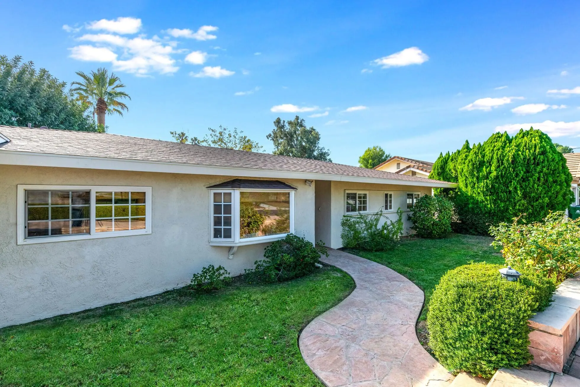 One-story house with bay window and green lawn