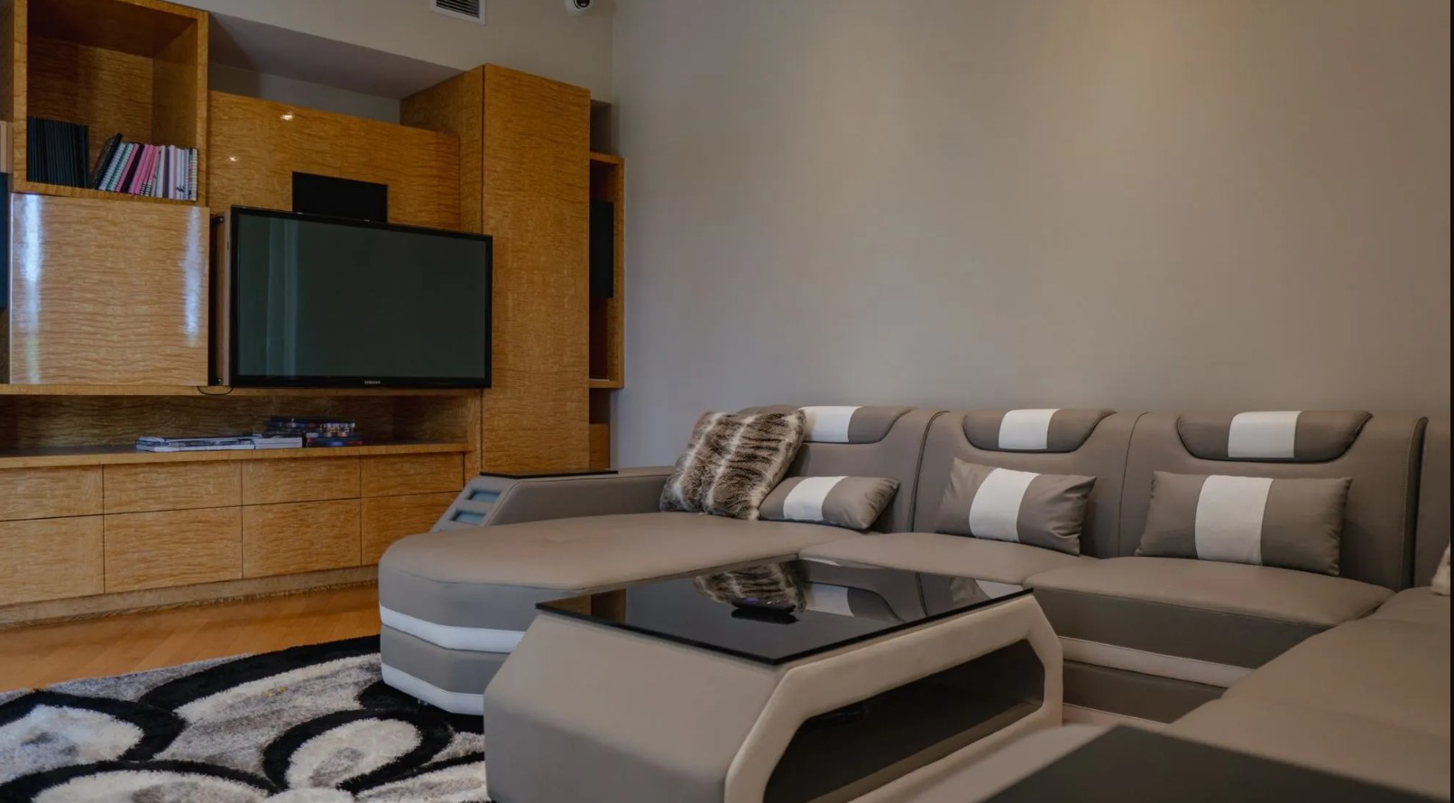 Comfortable media room with sectional seating, entertainment center, and large television