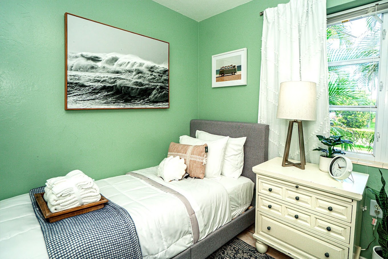 Cozy bedroom with green walls and soft lighting.
