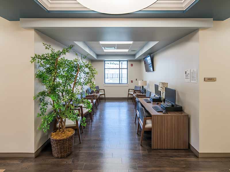 Hallway resource area with computers and seating inside addiction treatment center