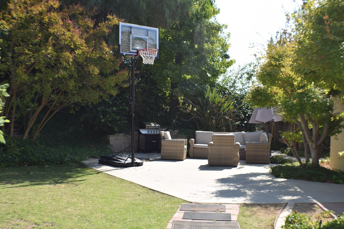 Outdoor lounge with basketball hoop and wicker furniture