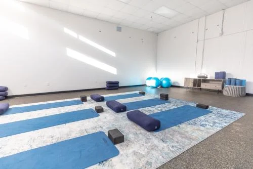 Yoga mats and bolsters arranged in bright studio