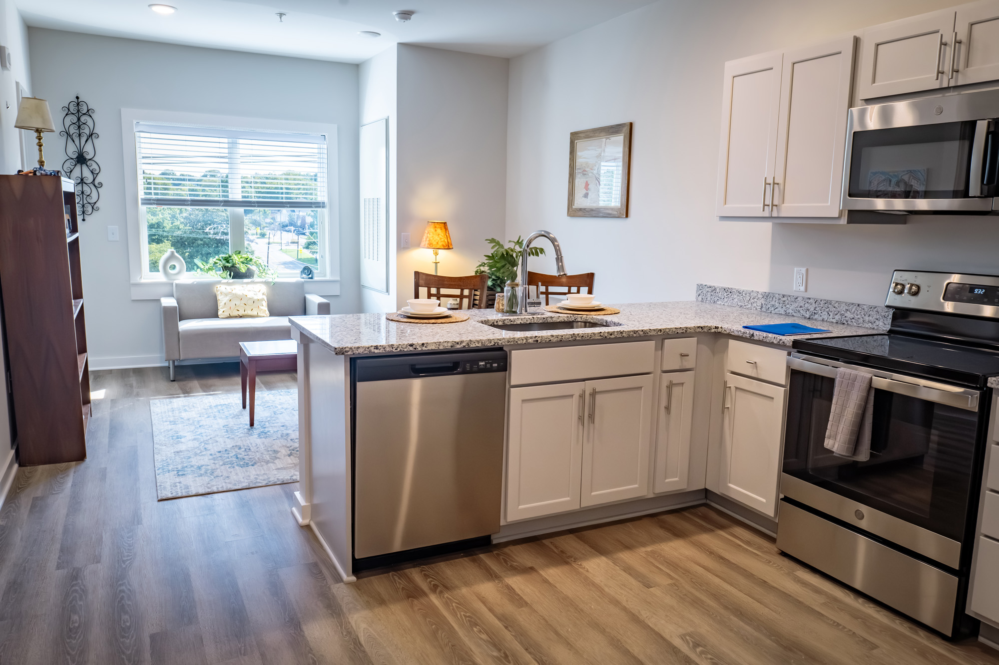 Modern kitchen with granite counter, seating, and sofa alcove