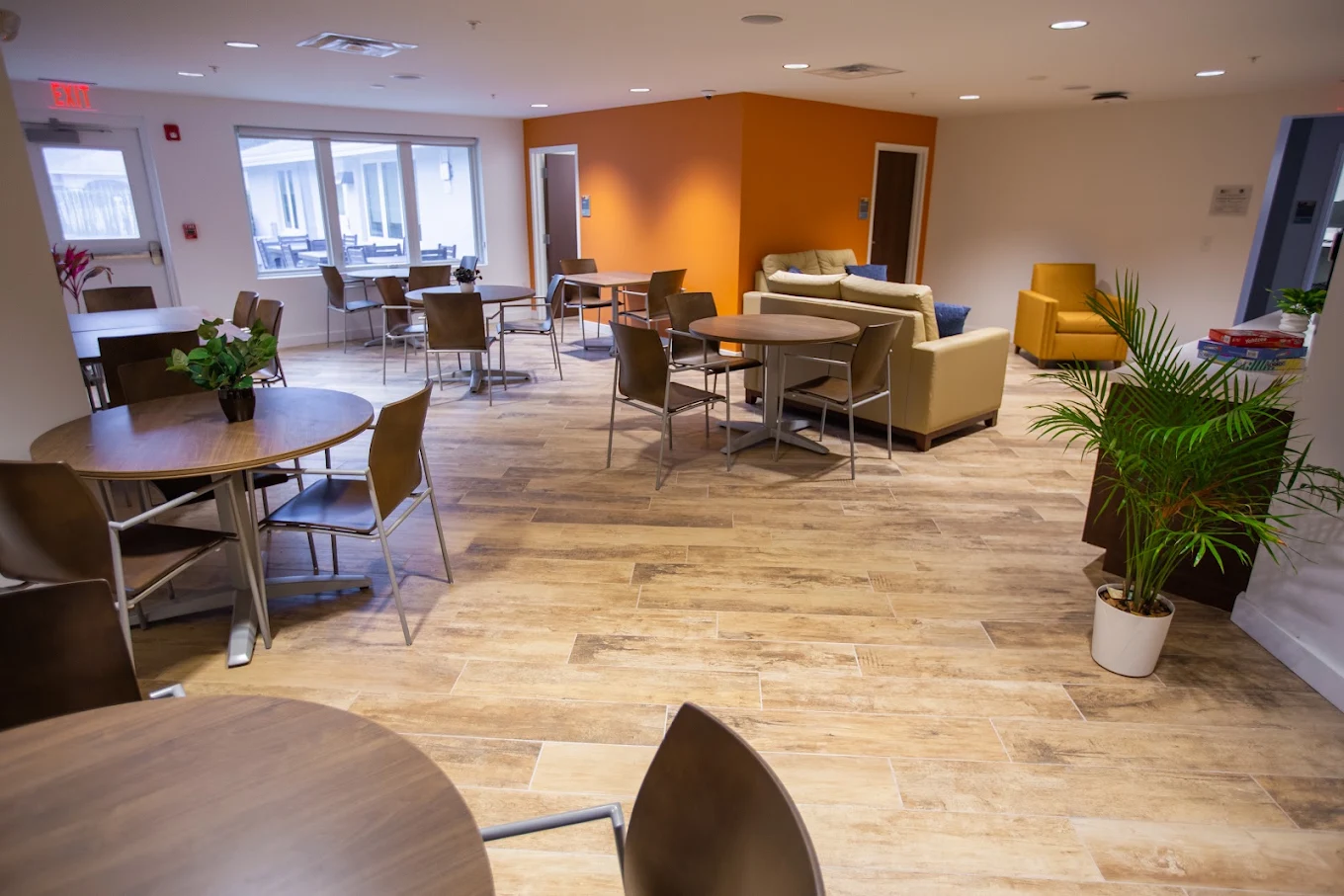 Communal room with tables, chairs, sofas, and indoor plants